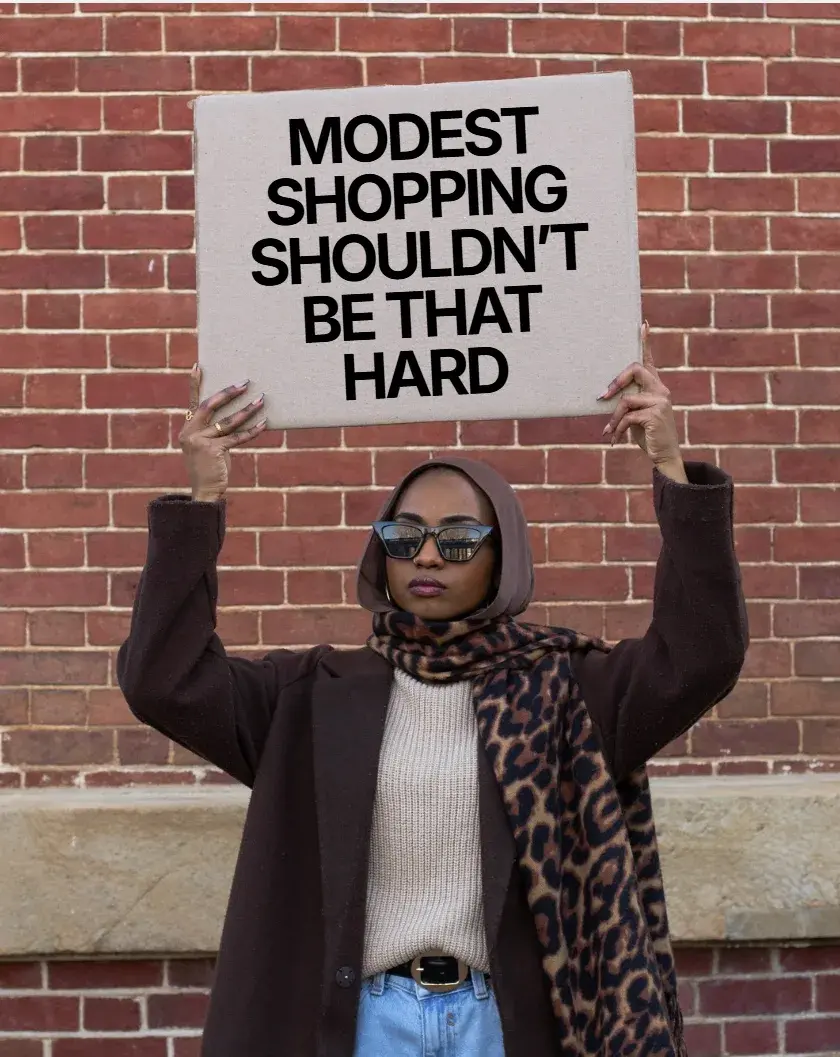 Shopper holding a sign reading modest shopping shouldn't be that hard