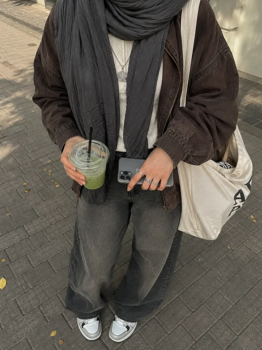 Shopper in an oversized jacket, scarf and wide-leg jeans on the street