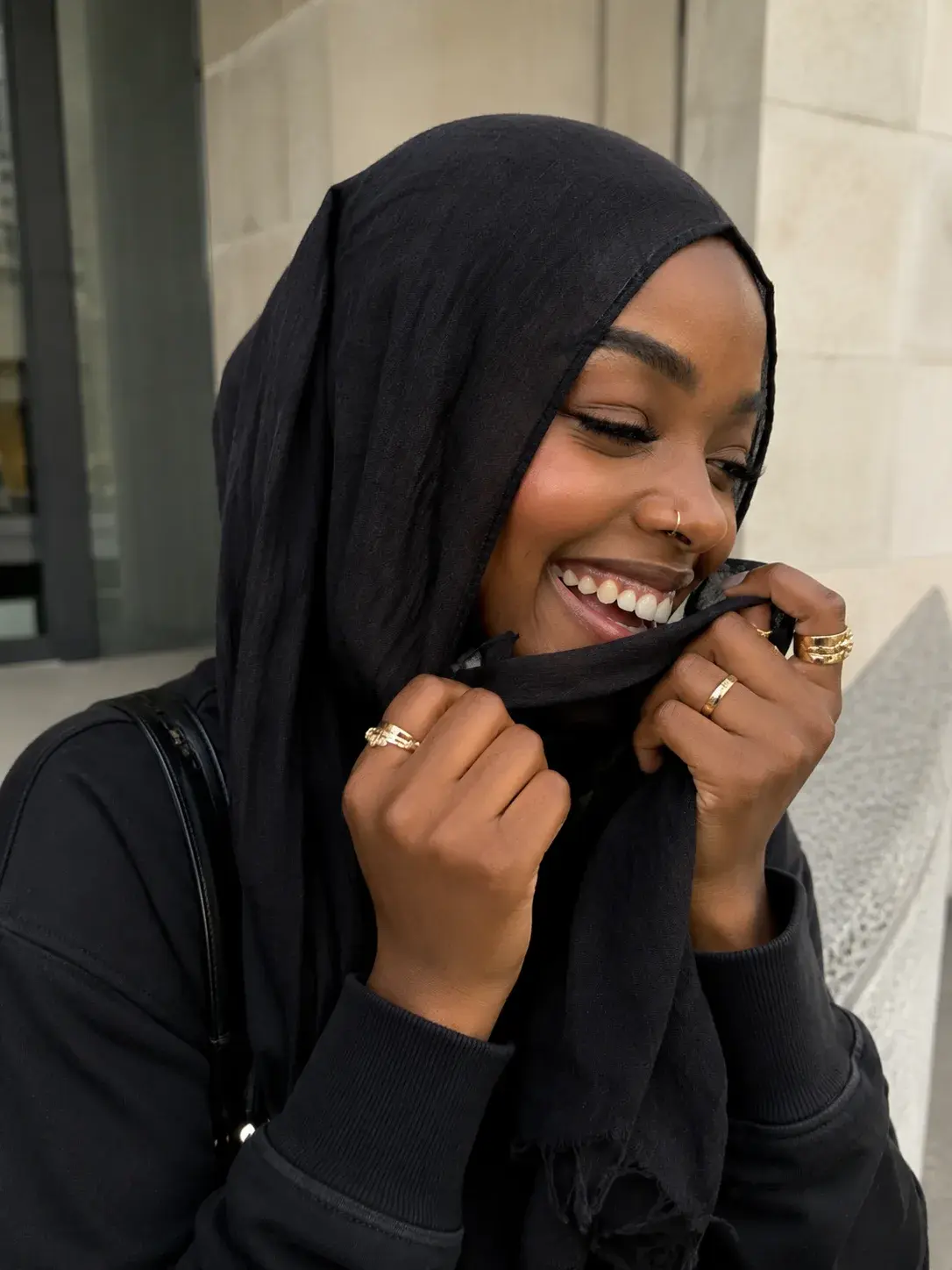 Shopper laughing while adjusting a black hijab