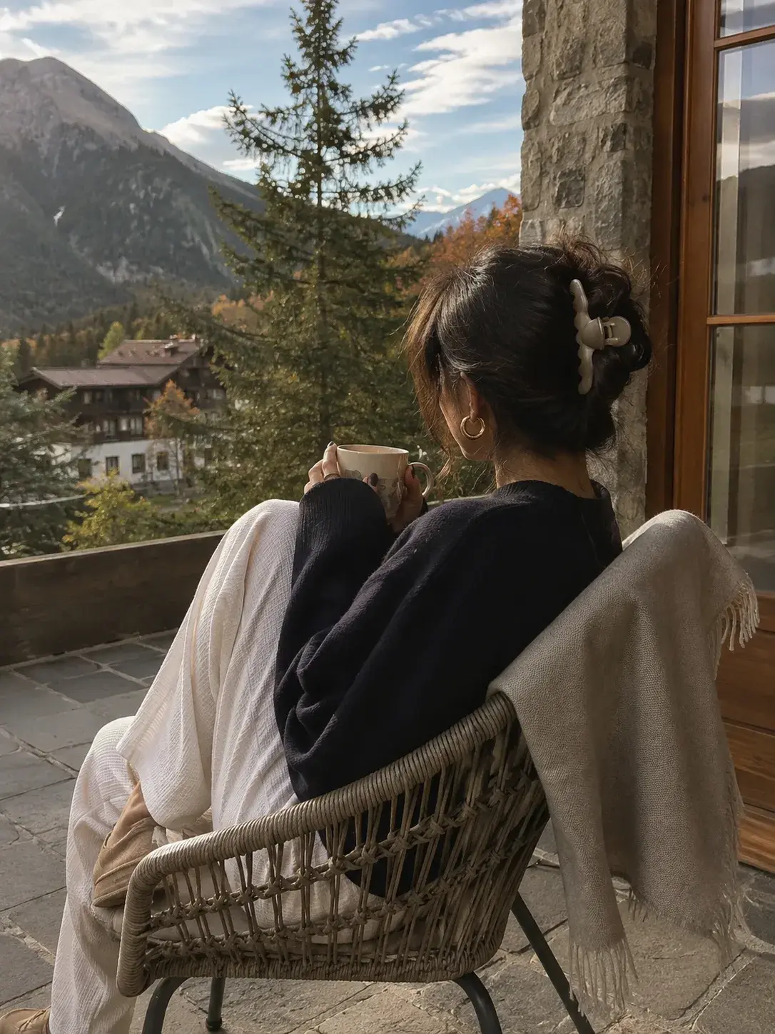 Shopper wrapped in a shawl looking out at a mountain view