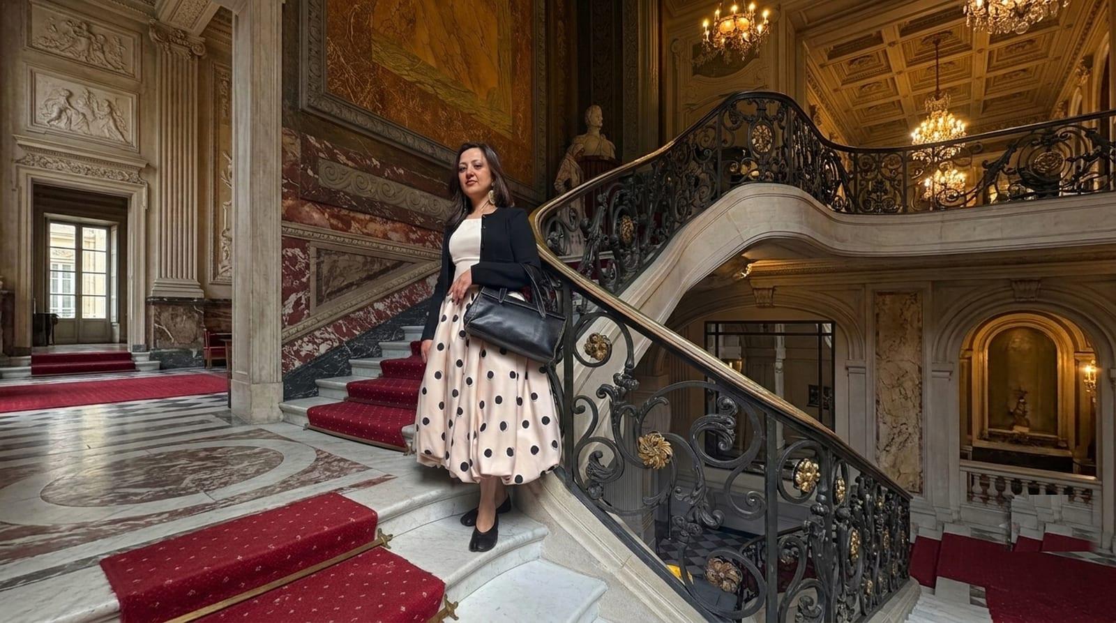 Shopper in a polka-dot midi skirt on a grand marble staircase